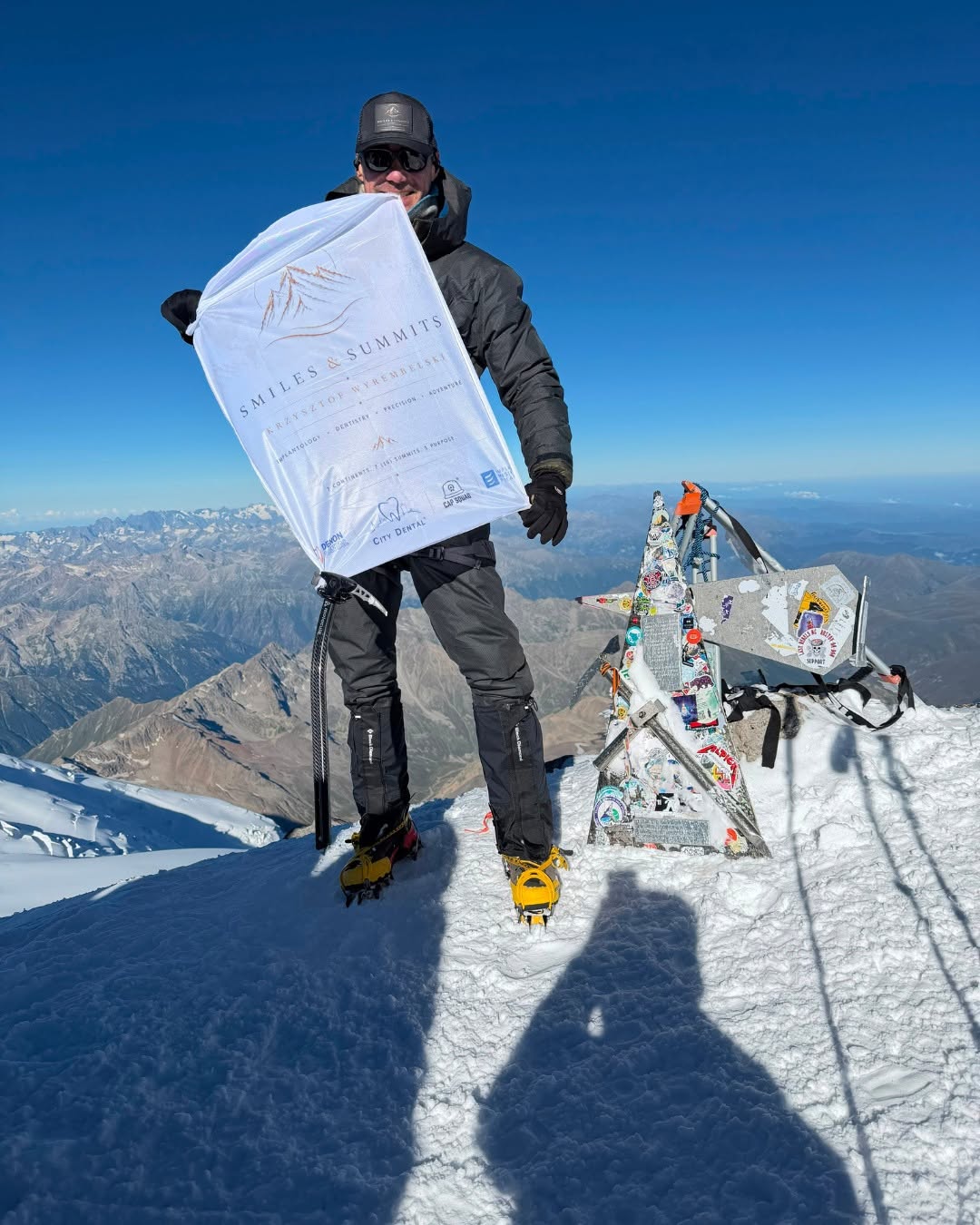 Krzysztof Wyrembelski z flagą Smiles & Summits na szczycie Elbrusu